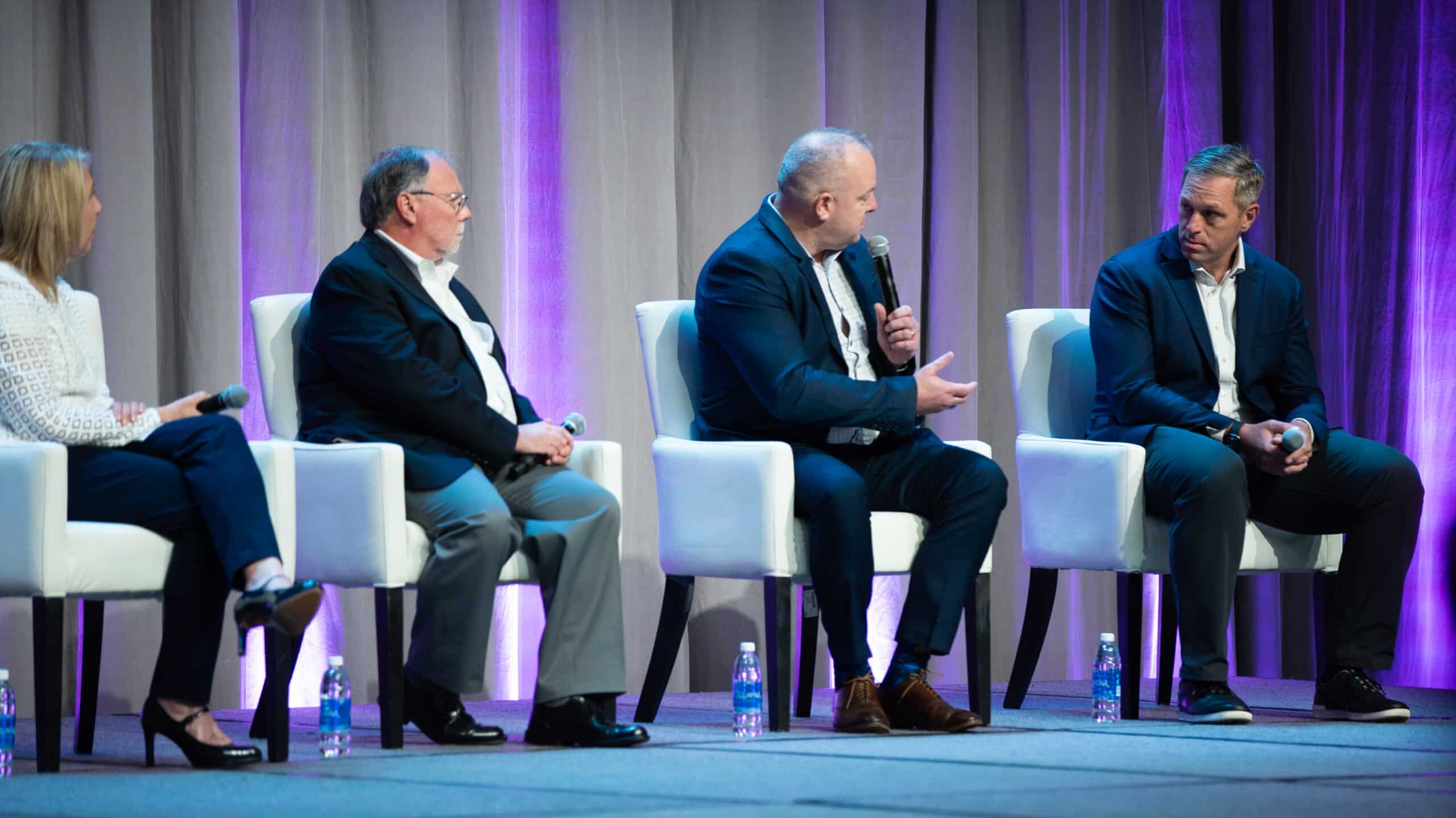 Four people on stage at a conference having a conversation